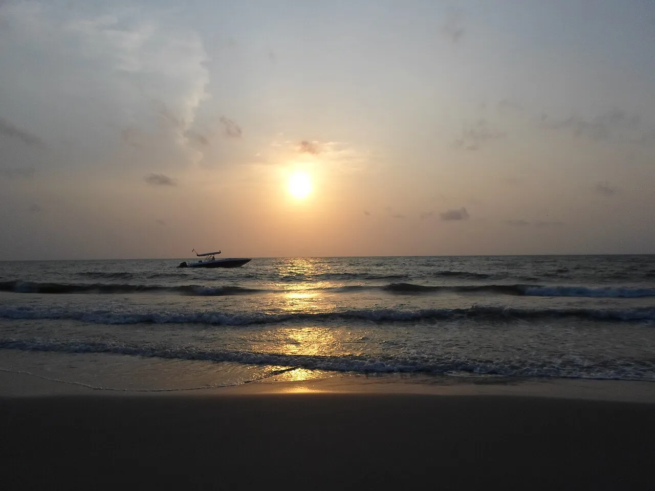 El sol sobre el mar de Necoclí y una lancha en el horizonte